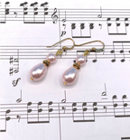 Pink pearl earrings on sheet music
